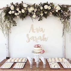 a table topped with cakes and cupcakes covered in frosting next to a sign that says ava sara