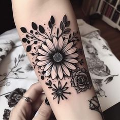 a woman's arm with black and white flowers on it