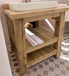 a bathroom with a sink and wooden shelves