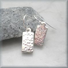 "Small dangle earrings - minimalist in nature but so cute! I hand hammered tiny little rectangles for texture and interest. The dimples are subtle - just enough to catch the line and add some shine. Each pair is unique and one of a kind as the marks are made by me! Great everyday earrings with a bit of flair! Earrings measure about 3/4\" (1.9 cm) long from top of earwire. All components are sterling silver. The hammered rectangles are 20 gauge silver tags. Jewelry is packaged in a cotton lined b Small Dangle Earrings, Metal Stamped Jewelry, Metal Smithing, Hammered Earrings, Rectangle Earrings, Jewelry Minimalist, Hammered Metal, Ear Rings, Geometric Jewelry