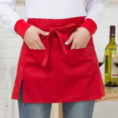 a woman wearing an apron with a bottle of wine in the background