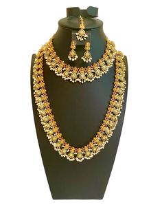 a necklace and earring set on a mannequin with gold jewelry pieces in the shape of flowers