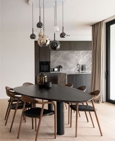 a dining room table and chairs in front of a sliding glass door