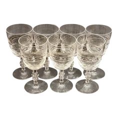 six crystal wine glasses are lined up in a row