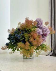 a vase filled with lots of different colored flowers