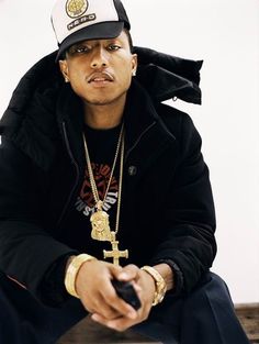 a man sitting on top of a wooden bench wearing a black jacket and white hat