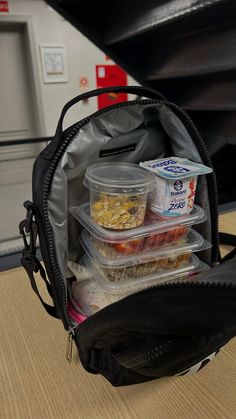 there are three plastic containers in the back of this backpack that is filled with food