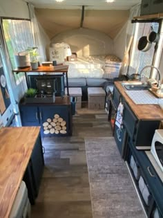 the interior of a camper with wood floors and furniture in it, including a stove top oven