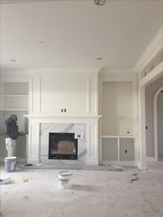 an empty living room with white walls and a fire place in the middle of it