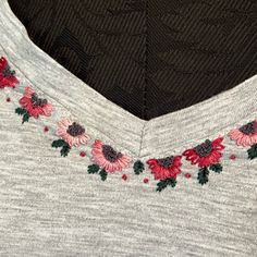 the back of a sweater with flowers embroidered on it