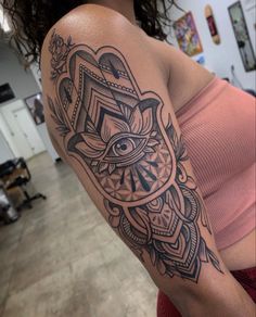 a woman's arm with an all seeing eye tattoo on her left shoulder and chest