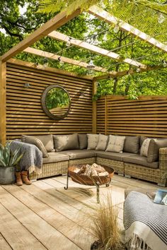 an outdoor living area with couches, tables and potted plants on the deck