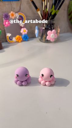 two little octopus figurines sitting on top of a table