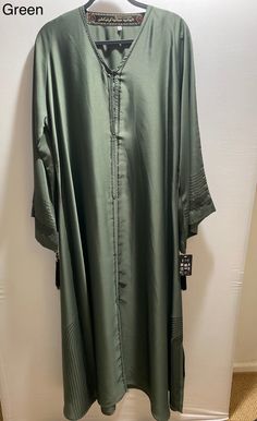 This elegant piece features a thoughtful design, made with Satin fabric and black gemstones, Made in UAE Dry Clean Only Length 56  Lose fit abaya Bohemian Green Embroidered Abaya, Elegant Green Embroidered Abaya, Green Long-sleeved Party Abaya, Green V-neck Abaya, Black Embellished Floor-length Abaya, Open Abaya, Satin Fabric, Dress Clothes For Women, Umbrella