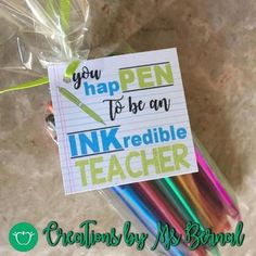 there is a bag with pens in it on the table next to a note that says, you have to be an inkedible teacher