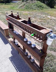 a wooden rack with bottles on it in the grass