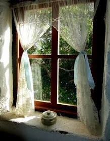 a window with sheer curtains and lace on it