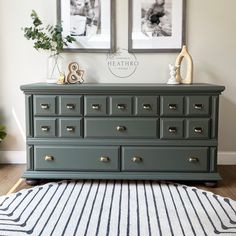 a dresser with two pictures above it and a rug on the floor in front of it