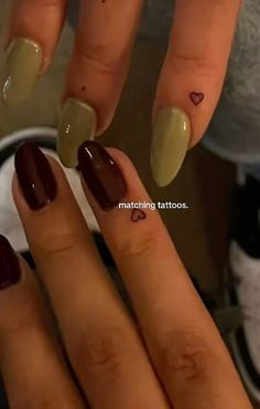 a woman's hand with two different colored nail polishes on her fingers and the words matching tattoos