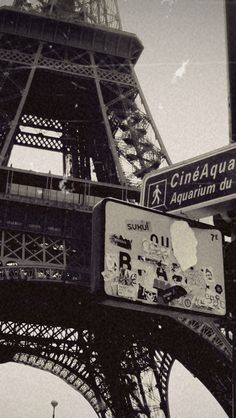 black and white photograph of the eiffel tower with street signs in paris, france