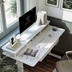 a white desk with a computer monitor and keyboard sitting on top of it next to a window