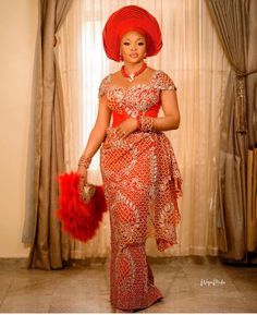 an african woman in a red and gold dress