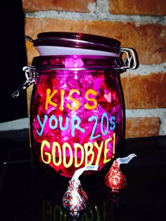 a jar filled with candy sitting on top of a table next to a brick wall