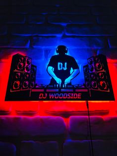 dj woodside neon sign on brick wall with blue and red light behind it,