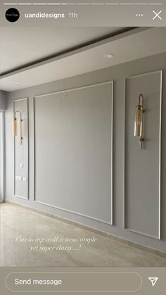 an empty room with white walls and two gold sconces on the wall next to each other