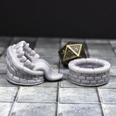 a close up of a small white object on a tile floor next to a dice