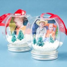 two snow globes that have pictures in them and red ribbon on the top one