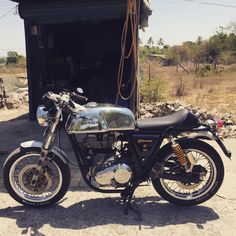 a motorcycle parked in front of a building with an open door on the other side