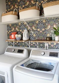 a washer and dryer in a room with floral wallpaper on the walls