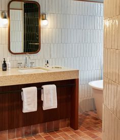 a bathroom with a sink, mirror and bathtub next to a tiled shower stall