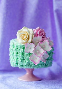 there is a cake decorated with flowers on the top and bottom, in pastel colors