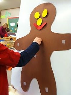 a child is making a paper cut out of a ginger