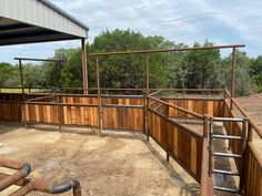 an outdoor area with wooden fence and metal railings