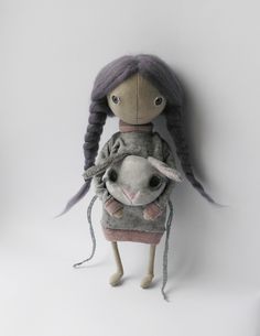 a doll holding a stuffed animal in it's arms on a white background with space for text