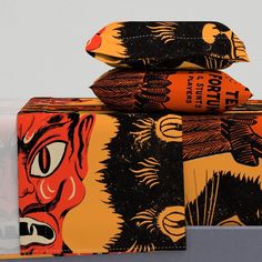 an orange and black case sitting on top of each other next to a box with two different designs