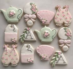 many decorated cookies are arranged in the shape of teapots, kettles and other items