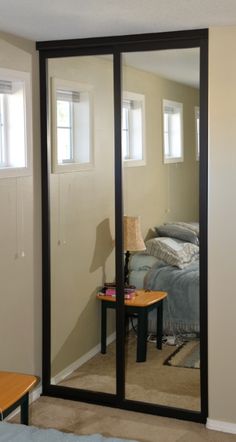 an empty room with a bed, couch and sliding glass doors that open up to the bedroom