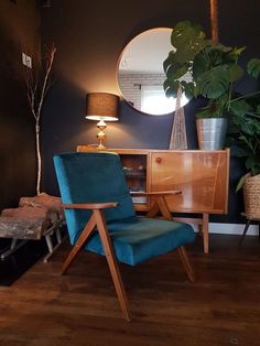 a blue chair sitting in front of a wooden table with a mirror on top of it