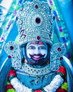 a close up of a person wearing a costume and headdress with jewels on it