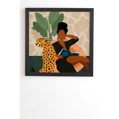 a woman sitting next to a cheetah holding a book