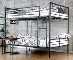 two bunk beds sitting next to each other on a hard wood floor in front of a brick wall