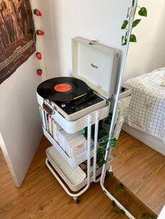 a record player is sitting on top of a cart with books and records in it