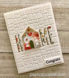 a card with the word home made out of paper and some flowers on it,