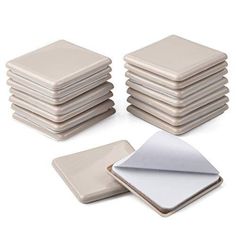 a stack of white square coasters sitting next to each other on a white surface