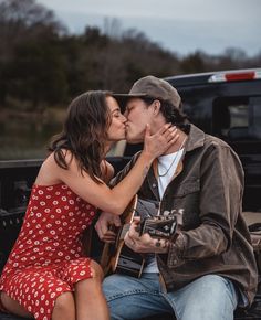 a man and woman kissing in the bed of a truck