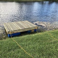 a wooden dock sitting on top of a lush green field